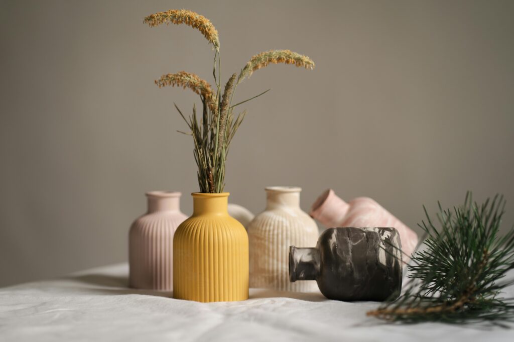 Collection of ceramic vases with dried flowers, capturing a minimalist aesthetic in soft, neutral tones.